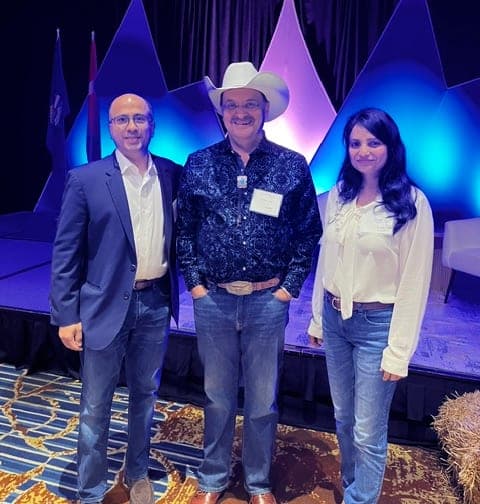Three attendees standing together in front of the stage at the Calgary Stampede